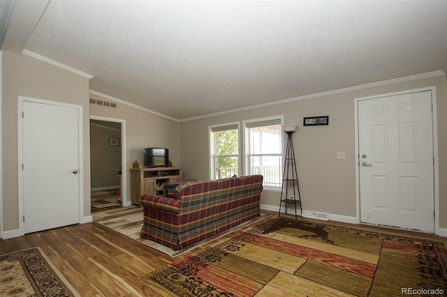 living room featuring hardwood / wood-style flooring, lofted ceiling, crown molding, and a textured ceiling