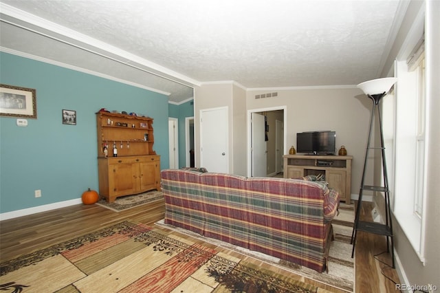 living room featuring a textured ceiling, wood-type flooring, lofted ceiling, and ornamental molding