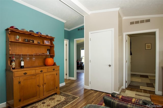 interior space featuring a textured ceiling, crown molding, dark wood-type flooring, and vaulted ceiling