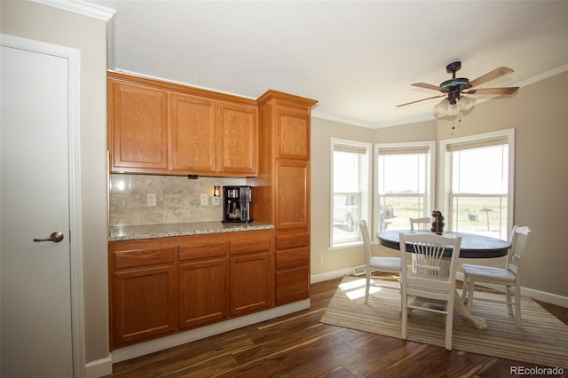 kitchen with decorative backsplash, ornamental molding, ceiling fan, and dark wood-type flooring