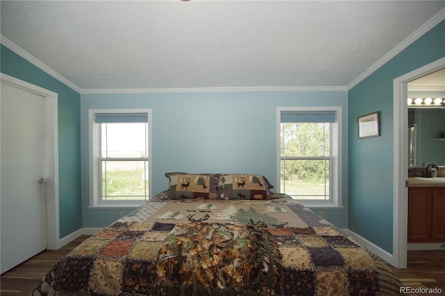 bedroom with wood-type flooring, multiple windows, and ensuite bath