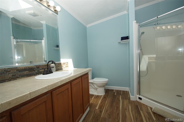 bathroom featuring vanity, a shower with door, crown molding, tasteful backsplash, and wood-type flooring