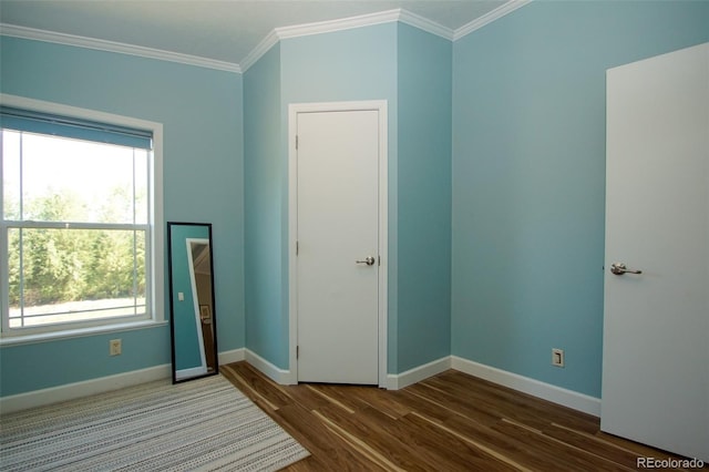 unfurnished bedroom with multiple windows, crown molding, and dark hardwood / wood-style floors