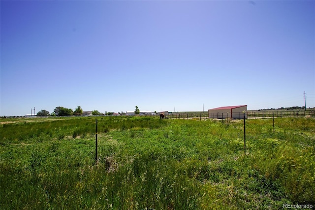 view of yard featuring a rural view and an outbuilding