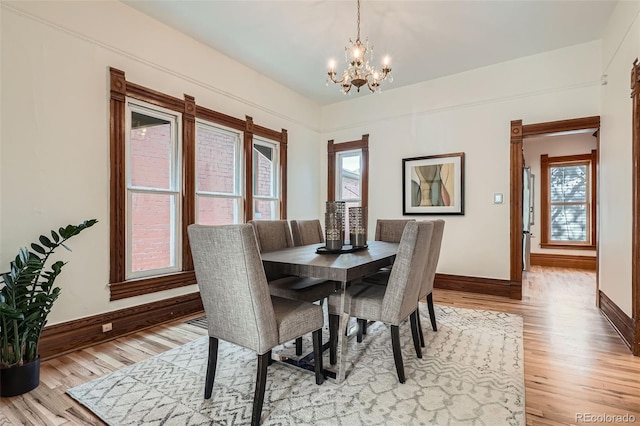 209 S Lincoln St, Denver, CO 80209 - dining space featuring a chandelier, baseboards, and light wood-style flooring