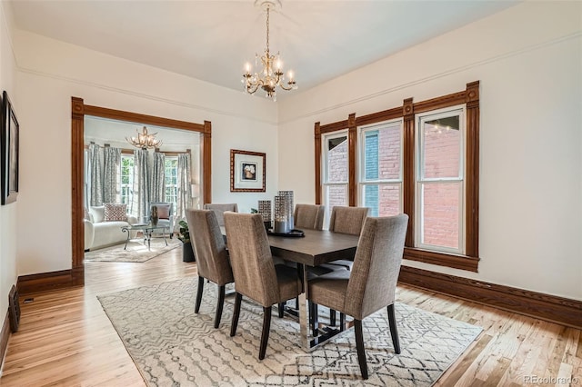209 S Lincoln St, Denver, CO 80209 - dining room with a chandelier, light wood finished floors, and baseboards
