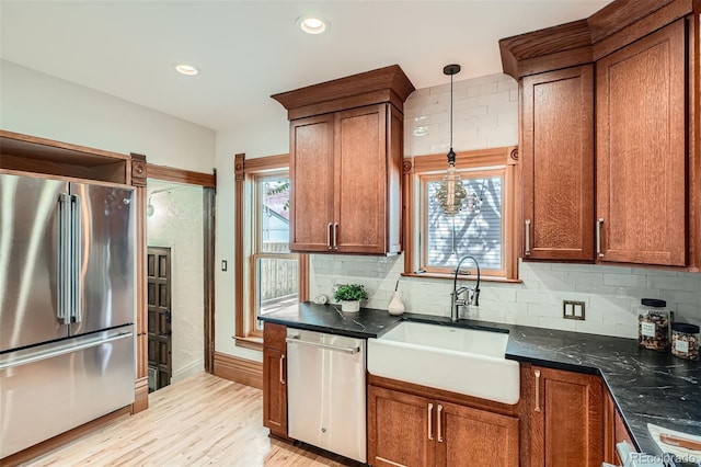 209 S Lincoln St, Denver, CO 80209 - kitchen with stainless steel appliances, a sink, tasteful backsplash, light wood-style floors, and decorative light fixtures