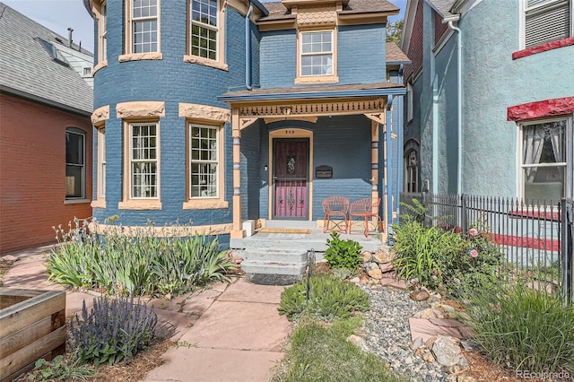 209 S Lincoln St, Denver, CO 80209 - property entrance featuring a porch, brick siding, and a shingled roof