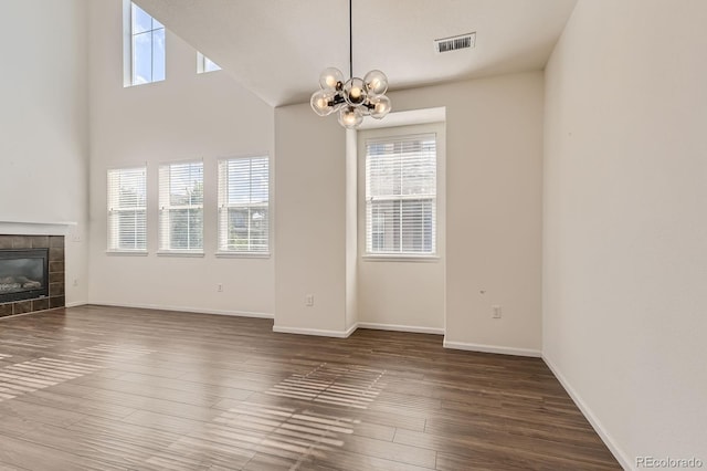 3491 Cascina Pl Unit D, Highlands Ranch, CO 80126 - unfurnished living room with a chandelier, plenty of natural light, wood finished floors, and a tile fireplace