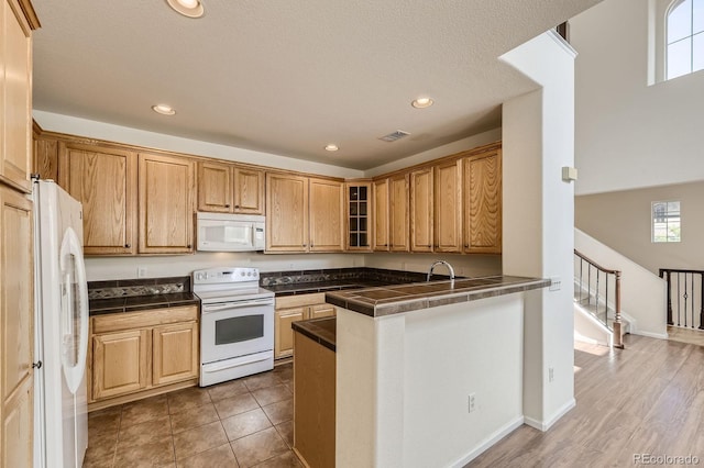 3491 Cascina Pl Unit D, Highlands Ranch, CO 80126 - kitchen featuring white appliances, glass insert cabinets, a peninsula, recessed lighting, and tile countertops