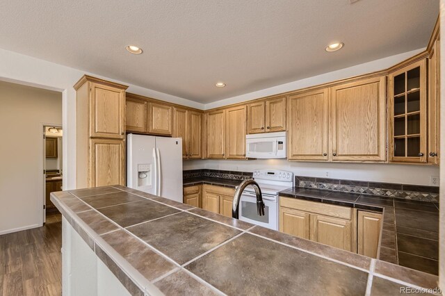 3491 Cascina Pl Unit D, Highlands Ranch, CO 80126 - kitchen featuring white appliances, dark countertops, glass insert cabinets, recessed lighting, and dark wood-style flooring