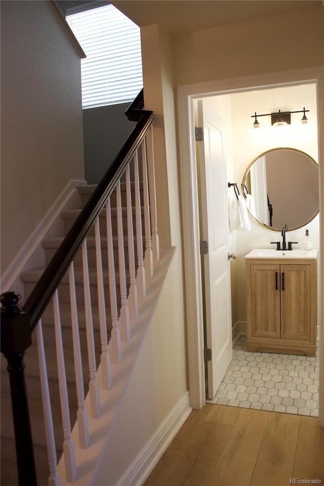 staircase featuring hardwood / wood-style flooring and sink