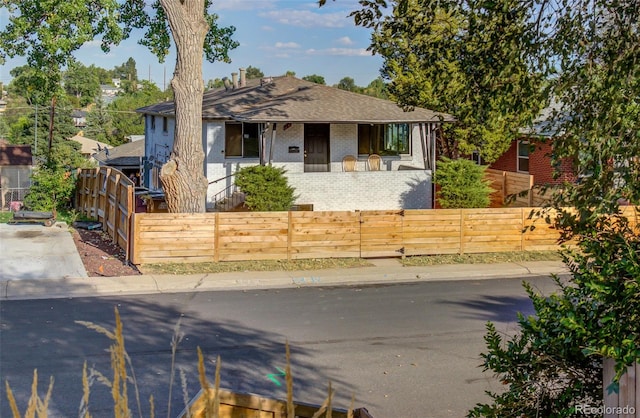 view of front of property with a fenced front yard and brick siding