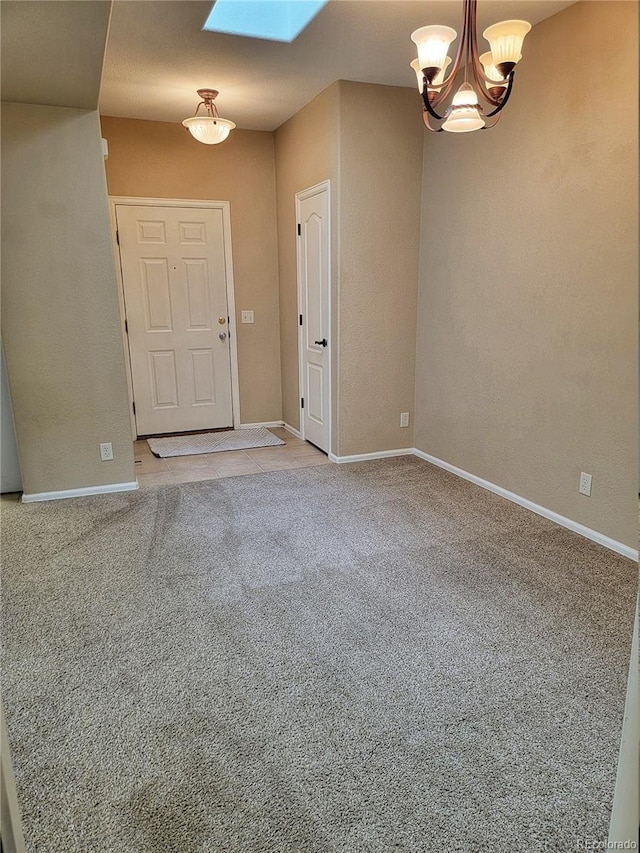 interior space featuring carpet, a skylight, and a chandelier