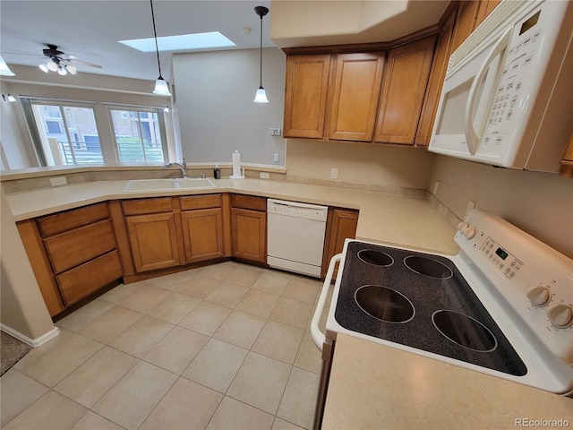 kitchen featuring a skylight, ceiling fan, sink, decorative light fixtures, and white appliances