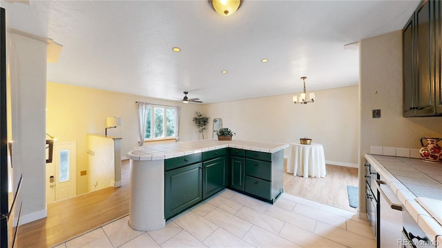 10718 Ash Ct, Thornton, CO 80233 - kitchen featuring tile countertops, green cabinetry, ceiling fan, a chandelier, and recessed lighting
