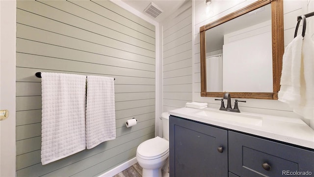 10718 Ash Ct, Thornton, CO 80233 - full bath with vanity, wood walls, and wood finished floors