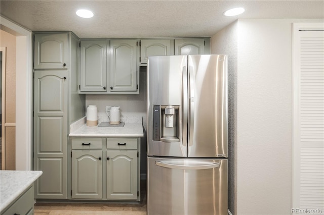 1409 S Moline St, Aurora, CO 80012 - kitchen featuring stainless steel fridge, green cabinets, and light countertops