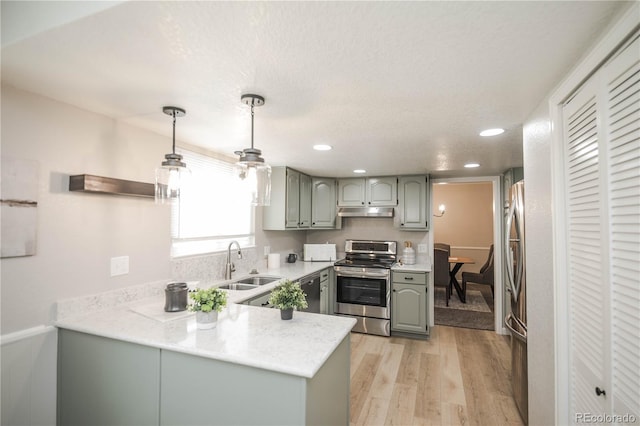 1409 S Moline St, Aurora, CO 80012 - kitchen with appliances with stainless steel finishes, under cabinet range hood, a peninsula, light wood-type flooring, and gray cabinets