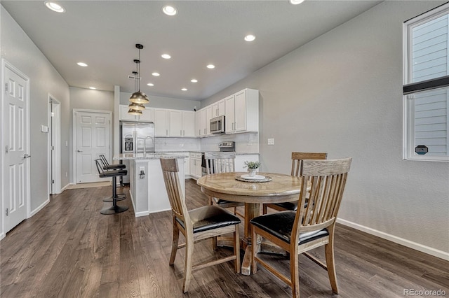 dining room featuring sink and dark wood-type flooring