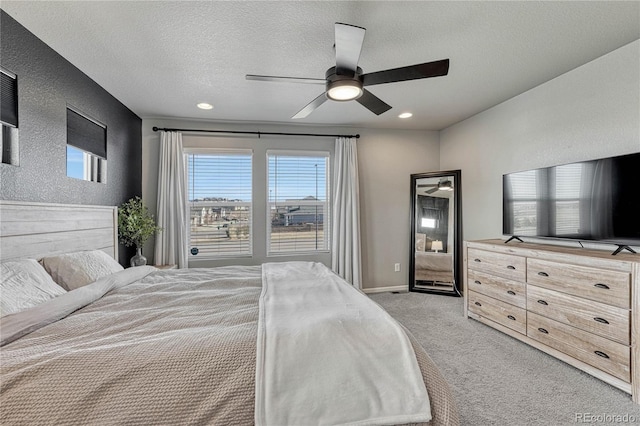 bedroom featuring ceiling fan, a textured ceiling, and light carpet