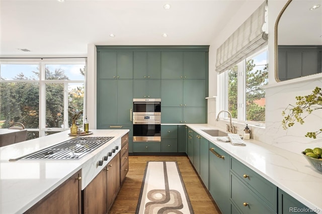 3220 Zuni St, Denver, CO 80211 - kitchen featuring green cabinets, light wood-type flooring, tasteful backsplash, double oven, and light stone counters