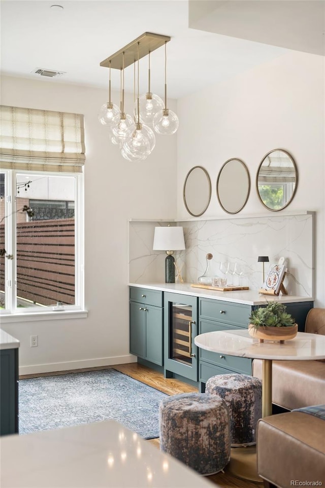 3220 Zuni St, Denver, CO 80211 - indoor bar featuring wine cooler, decorative backsplash, light wood-style floors, and plenty of natural light