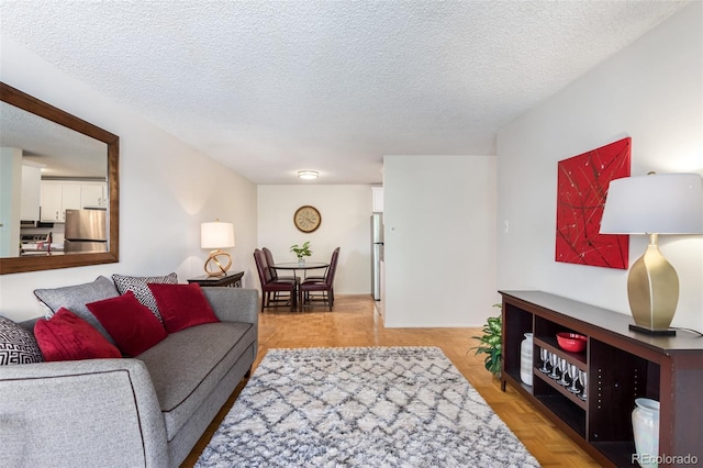 living room with a textured ceiling and light parquet floors