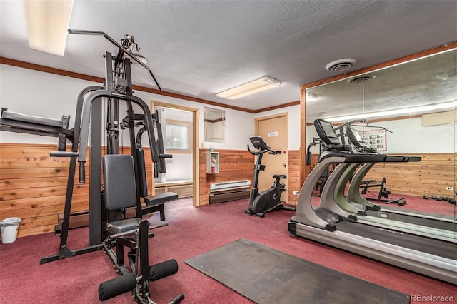 exercise area featuring a textured ceiling and carpet flooring