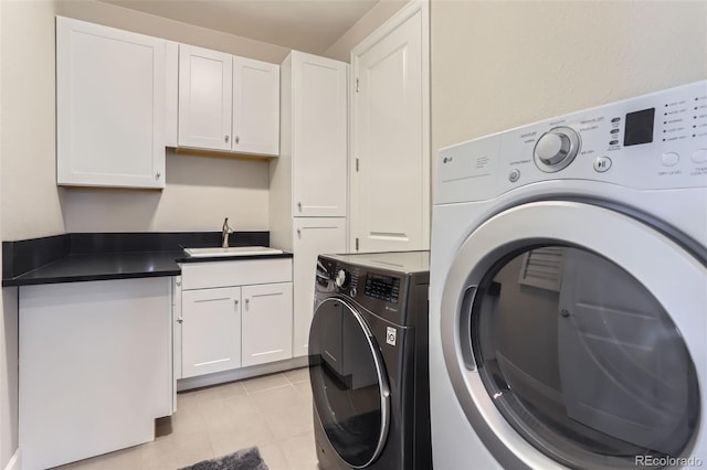 laundry area with sink, cabinets, washing machine and dryer, and light tile patterned floors