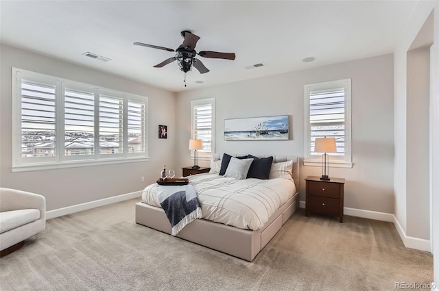 bedroom featuring baseboards, visible vents, a ceiling fan, and light colored carpet