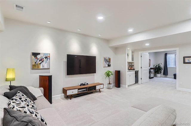 living area featuring baseboards, recessed lighting, visible vents, and light colored carpet