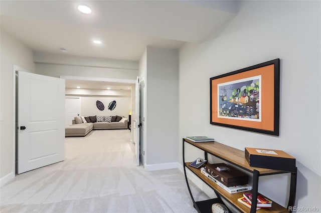 hallway with recessed lighting, light colored carpet, and baseboards