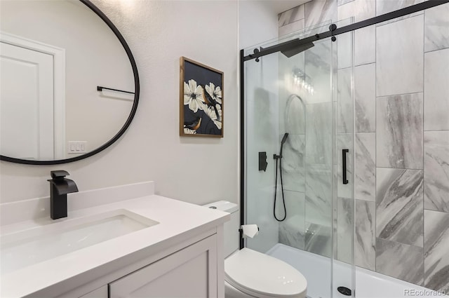 full bath featuring a stall shower, vanity, and toilet