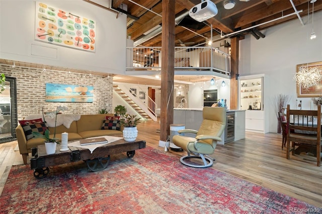 interior space featuring brick wall, a high ceiling, beverage cooler, and hardwood / wood-style floors