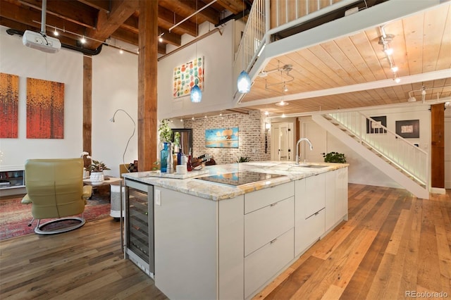 kitchen with white cabinets, wooden ceiling, brick wall, and wine cooler