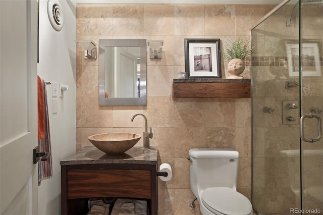 bathroom with toilet, walk in shower, vanity, and tile walls