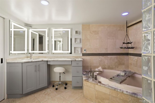 bathroom featuring tiled bath, tile patterned floors, and vanity