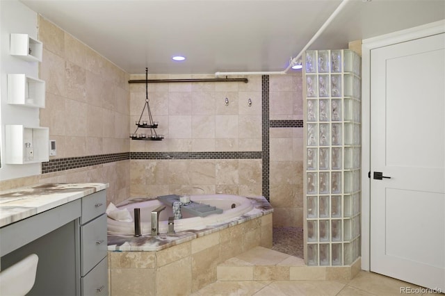 bathroom featuring tile patterned floors, vanity, tile walls, and independent shower and bath