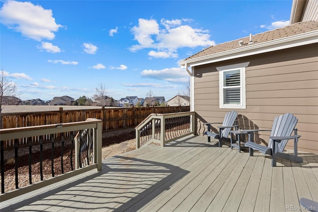 wooden terrace with a fenced backyard