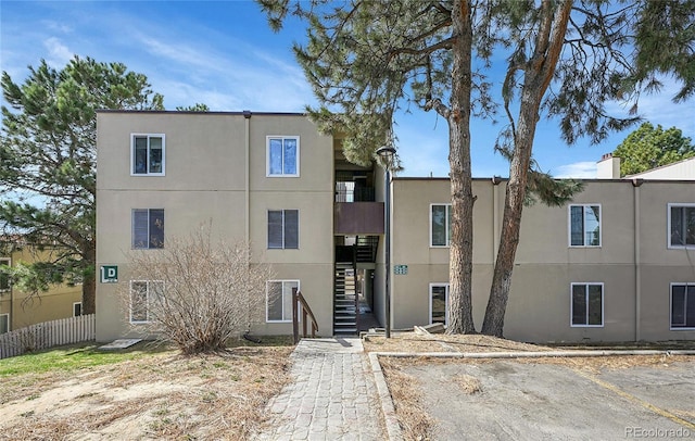 view of building exterior with stairs and fence