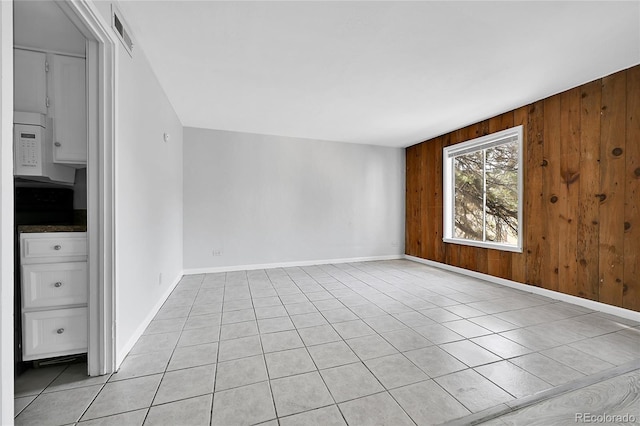 9700 E Iliff Ave Unit D44, Denver, CO 80231 - empty room with wooden walls, baseboards, and light tile patterned floors