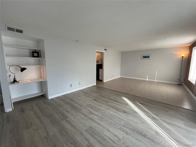 9700 E Iliff Ave Unit D44, Denver, CO 80231 - unfurnished living room with wood finished floors, built in features, and baseboards