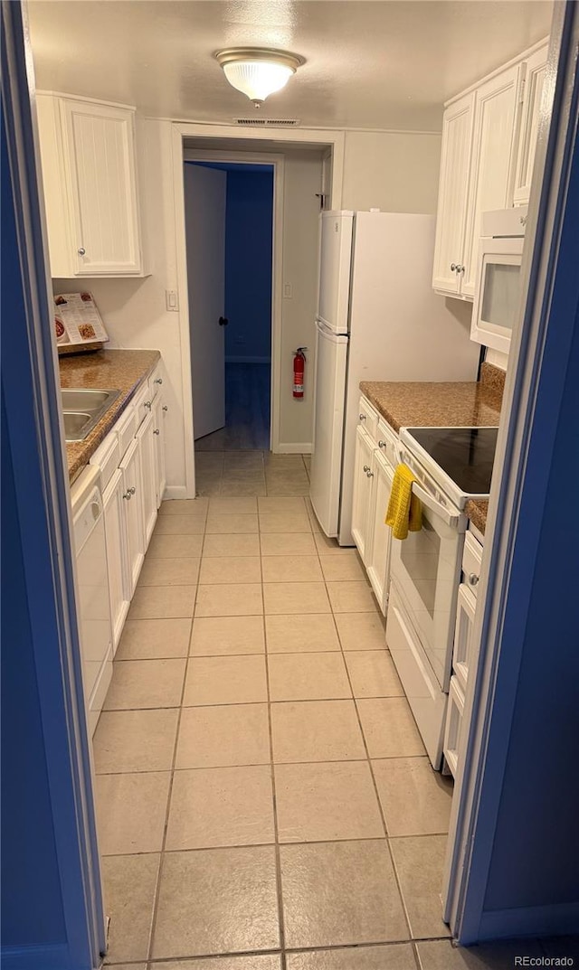 9700 E Iliff Ave Unit D44, Denver, CO 80231 - kitchen with white appliances, light tile patterned floors, white cabinets, and dark countertops
