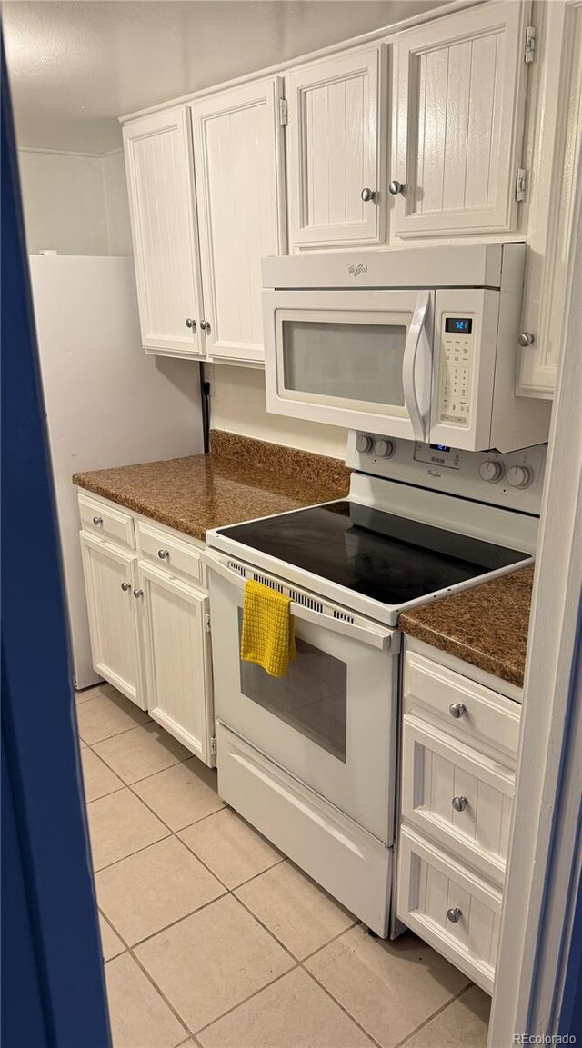 9700 E Iliff Ave Unit D44, Denver, CO 80231 - kitchen featuring white appliances, light tile patterned floors, white cabinetry, and dark stone countertops