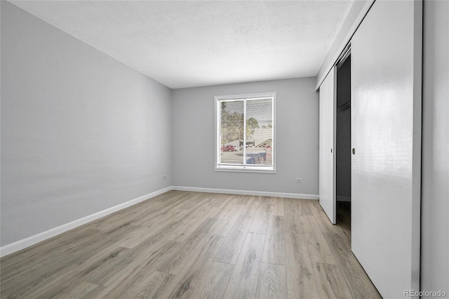9700 E Iliff Ave Unit D44, Denver, CO 80231 - unfurnished bedroom with light wood finished floors, a textured ceiling, baseboards, and a closet