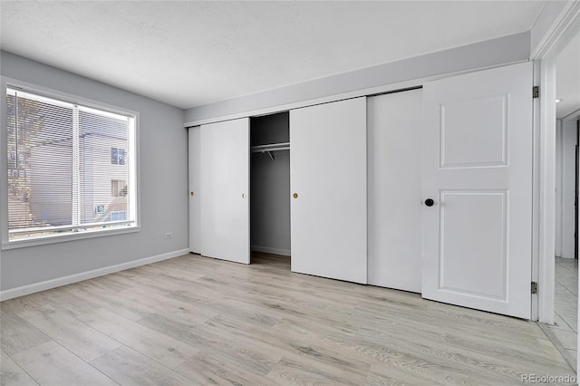 9700 E Iliff Ave Unit D44, Denver, CO 80231 - unfurnished bedroom featuring light wood-type flooring, a closet, and baseboards
