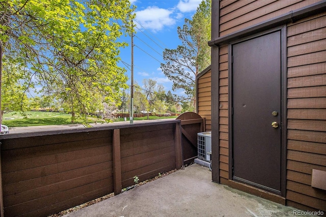 view of patio with a balcony and cooling unit