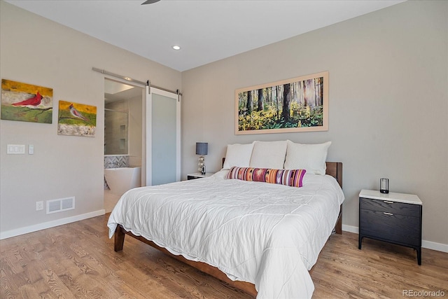 756 Dreamcatcher Ln, Evergreen, CO 80439 - bedroom featuring a barn door, wood finished floors, baseboards, recessed lighting, and connected bathroom