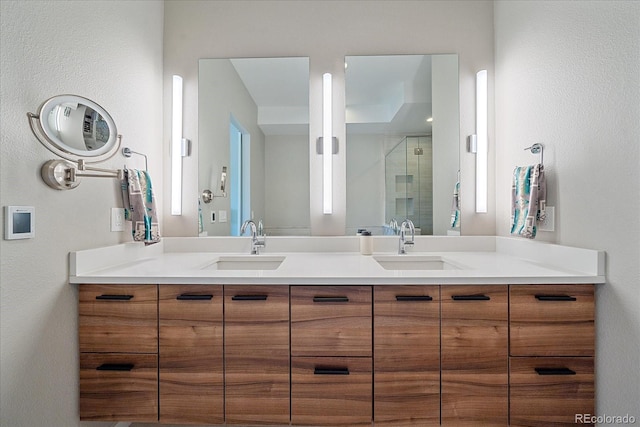 bathroom featuring a shower with door and vanity